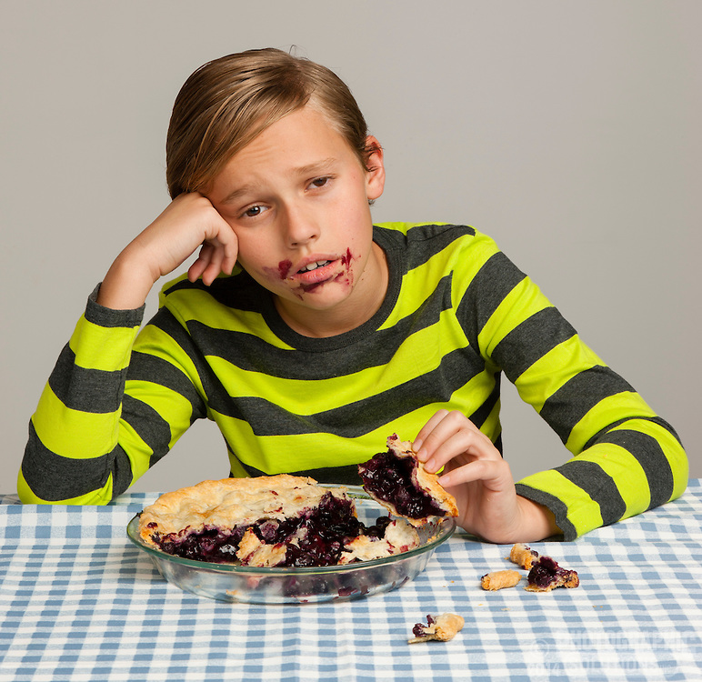 Boy eating too much pie